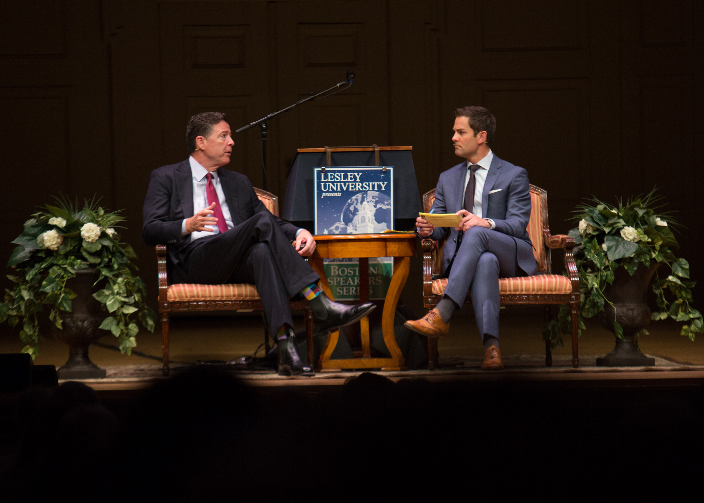 James Comey and Jared Bowen seats on the Symphony Hall stage
