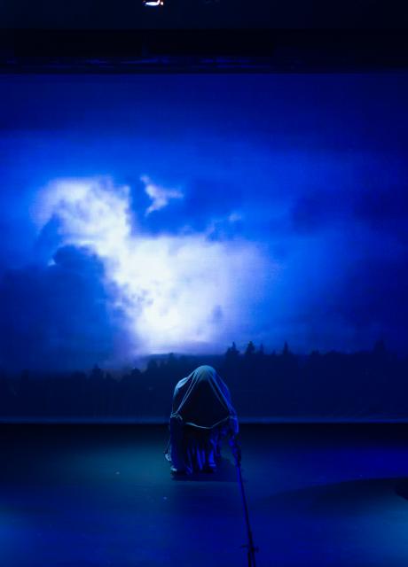A photograph of the Marran Theater stage during a dress rehearsal of the Oxford Street Players porduction of Macbeth with three witches in front of a screen of blue clouds