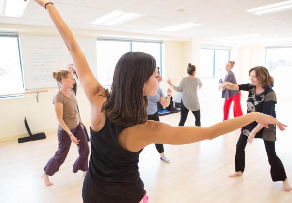 Students dance in a brightly lit studio.