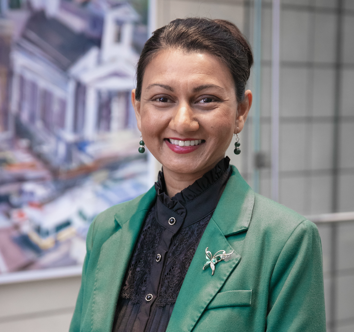 Gloria Noronha stands in a green blazer