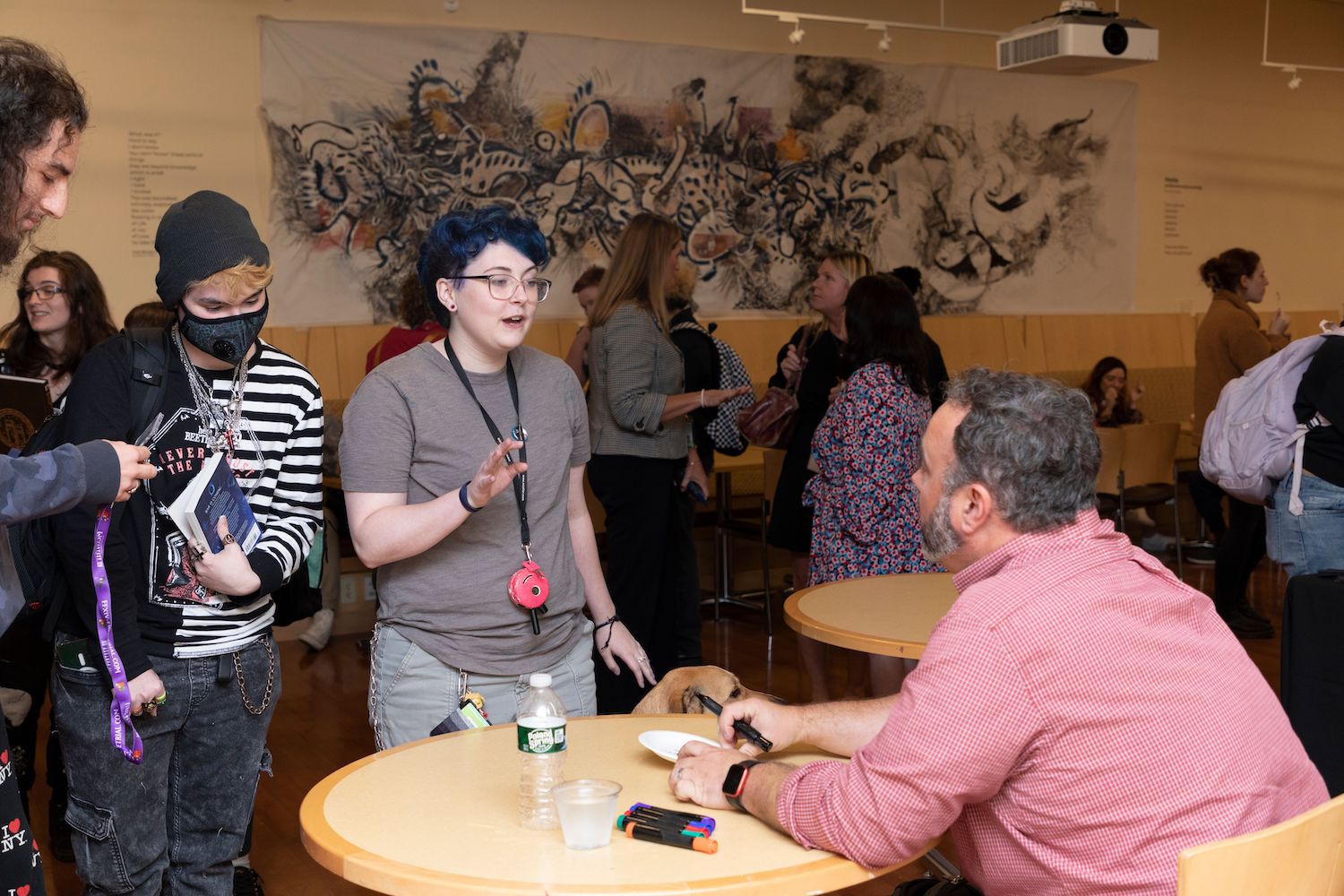 Justin Richmond sits at a table and speaks with Lesley students