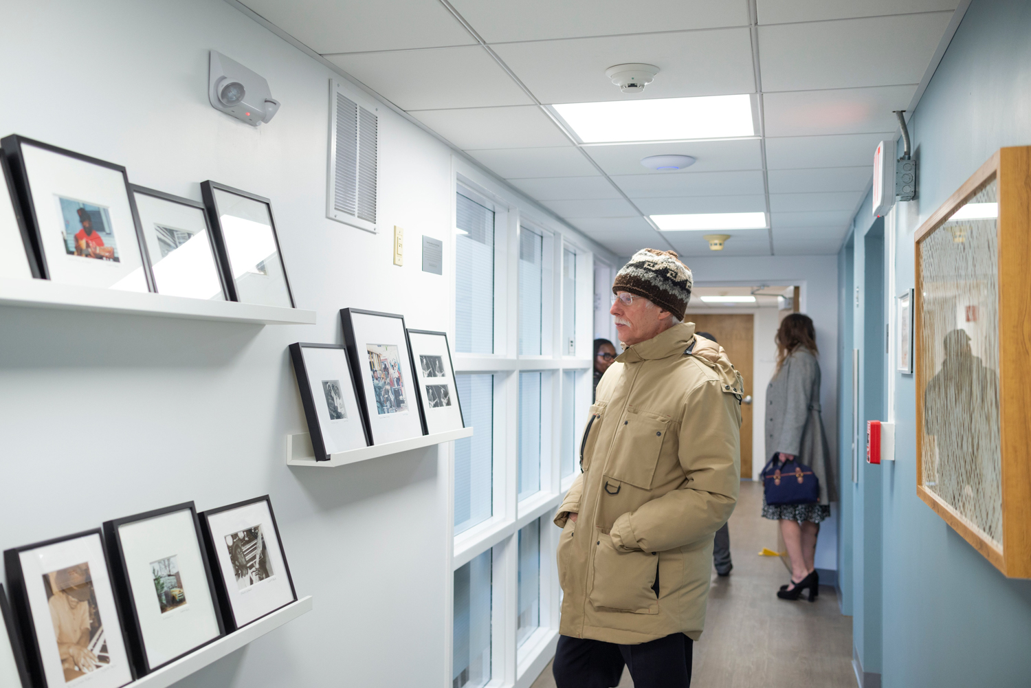 A man views framed pictures on a wall inside Riverside Outpatient Center