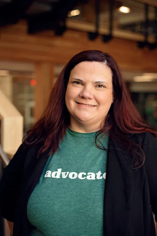 Sara smiling with green shirt that says "advocate"