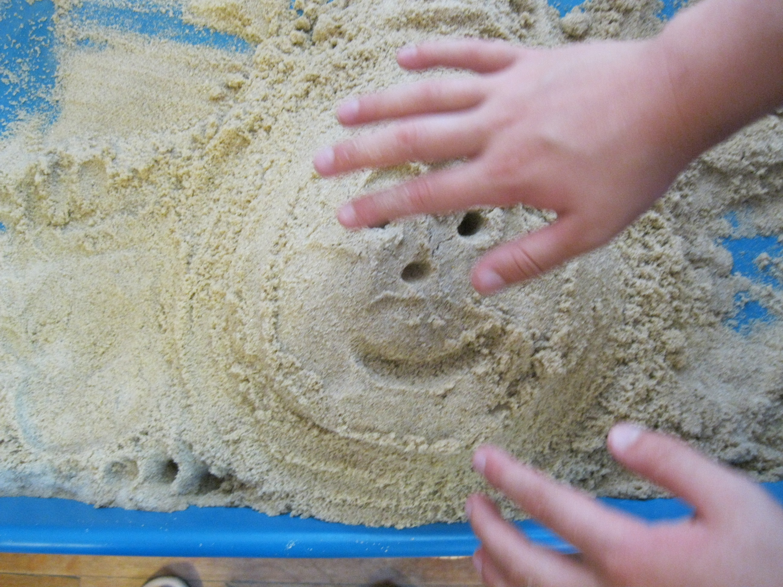 image of child's hand in sand tray