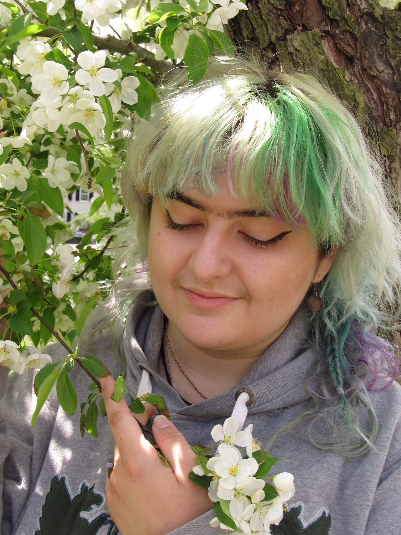 student amanda ciarletto standing next to a blossoming tree