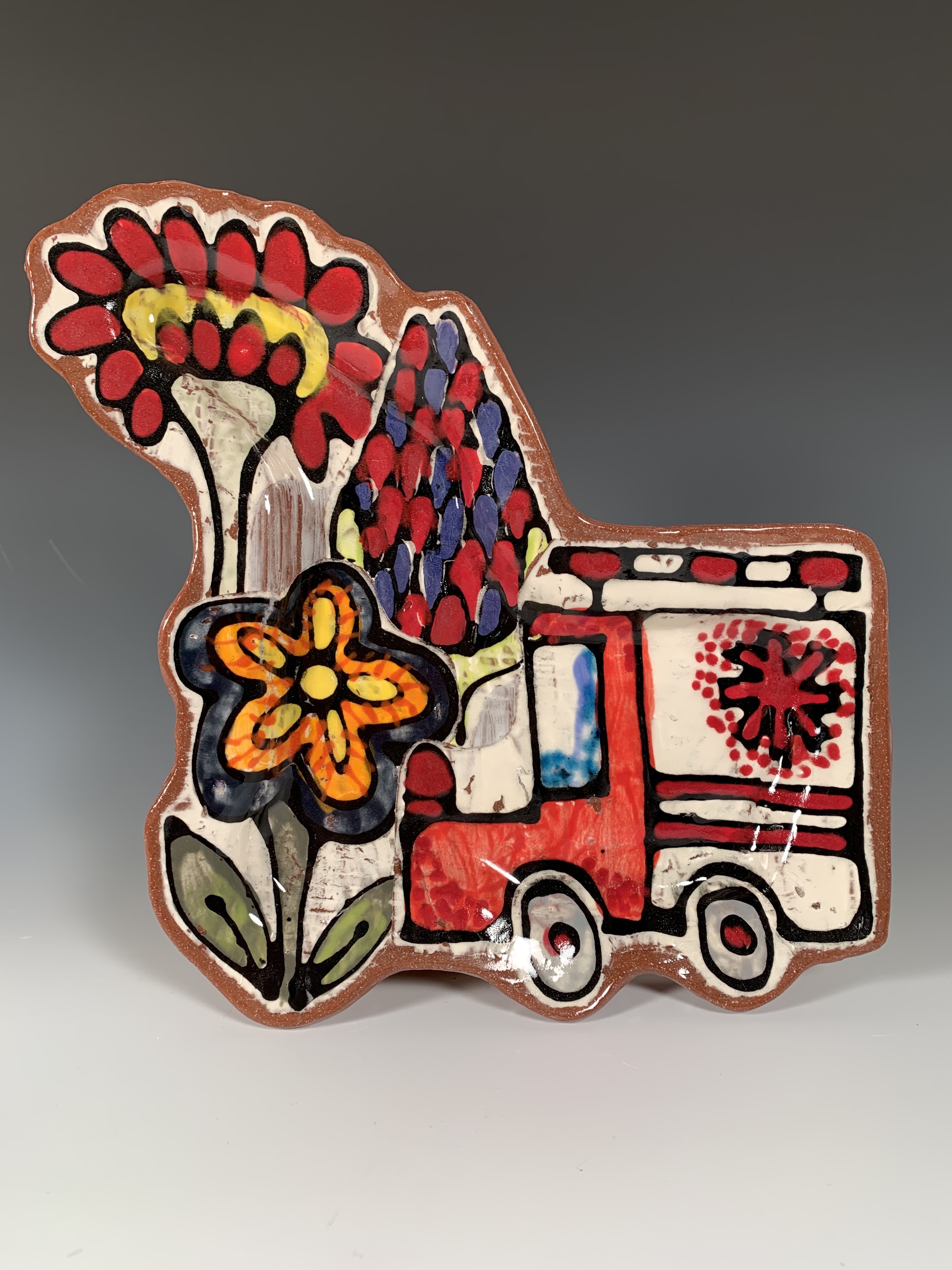 Plate painted with image of an ambulance and flowers