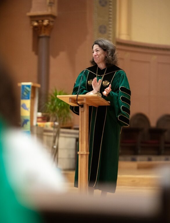 President Janet L. Steinmayer at podium, wearing academic regalia