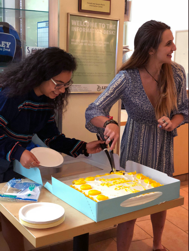 Students slice and serve birthday cake in the student center