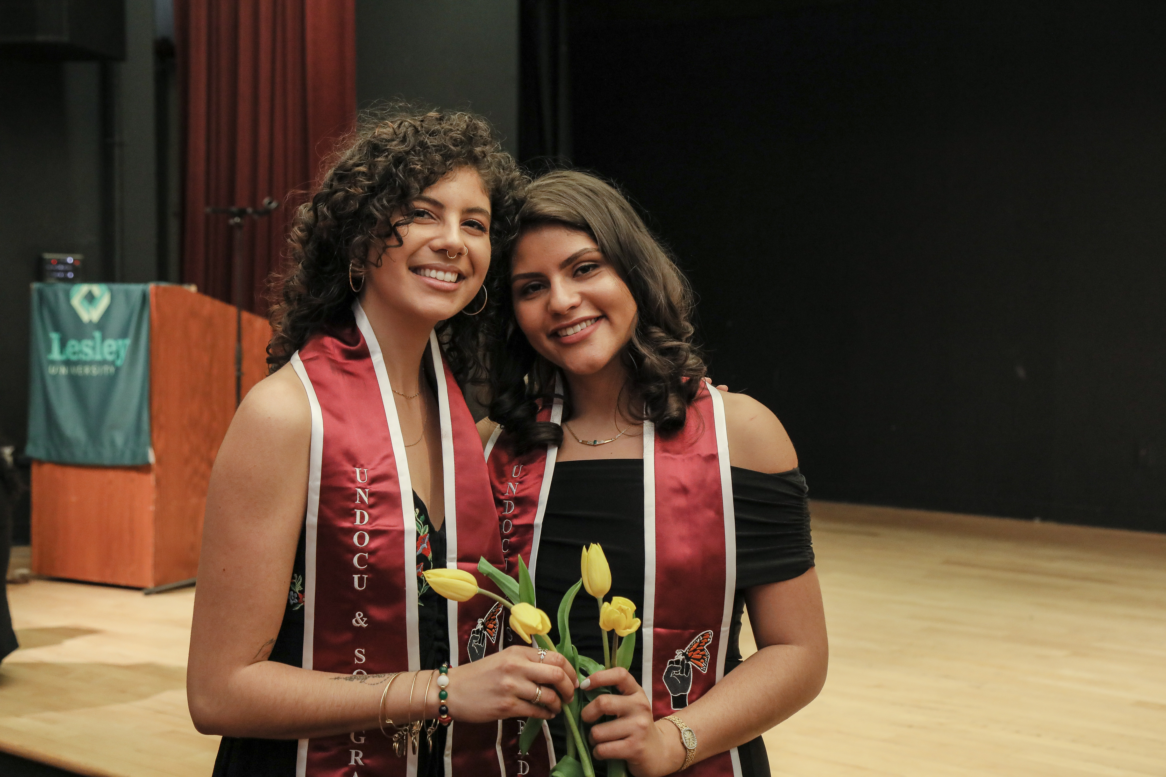 Jeannine Hernandez and Vita Franjul wearing the crimson stoles each graduate received