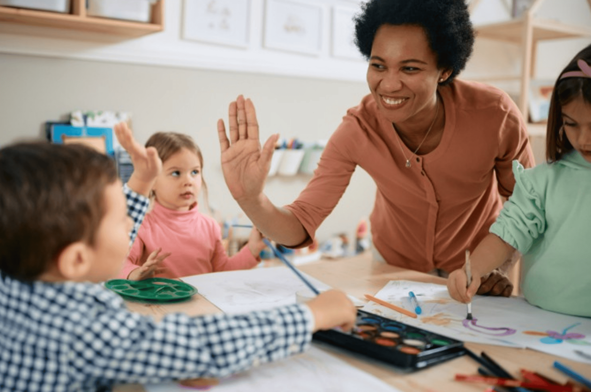 Literacy teacher high-fiving a young student
