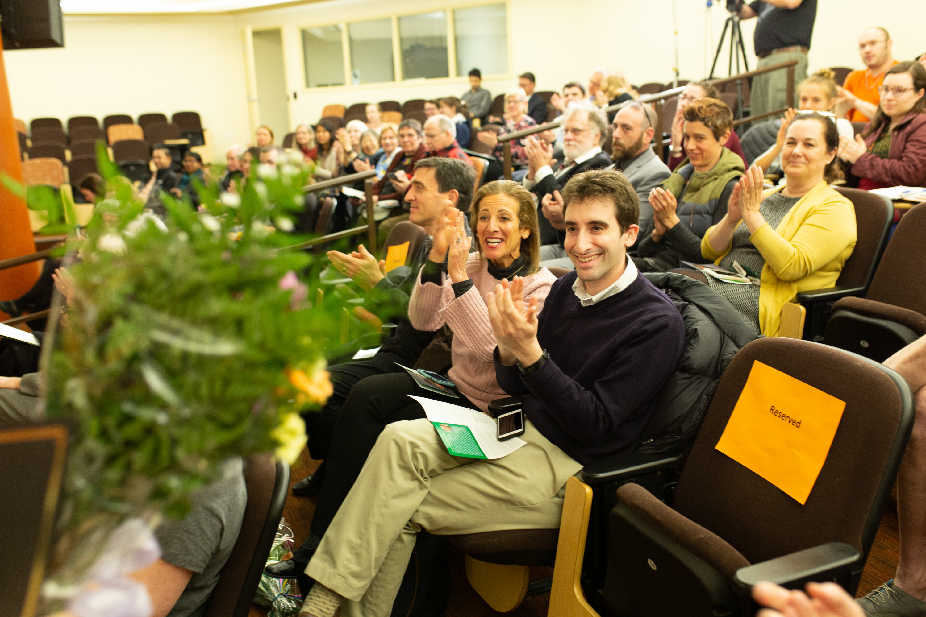 Members of the audience are pictured applauding.