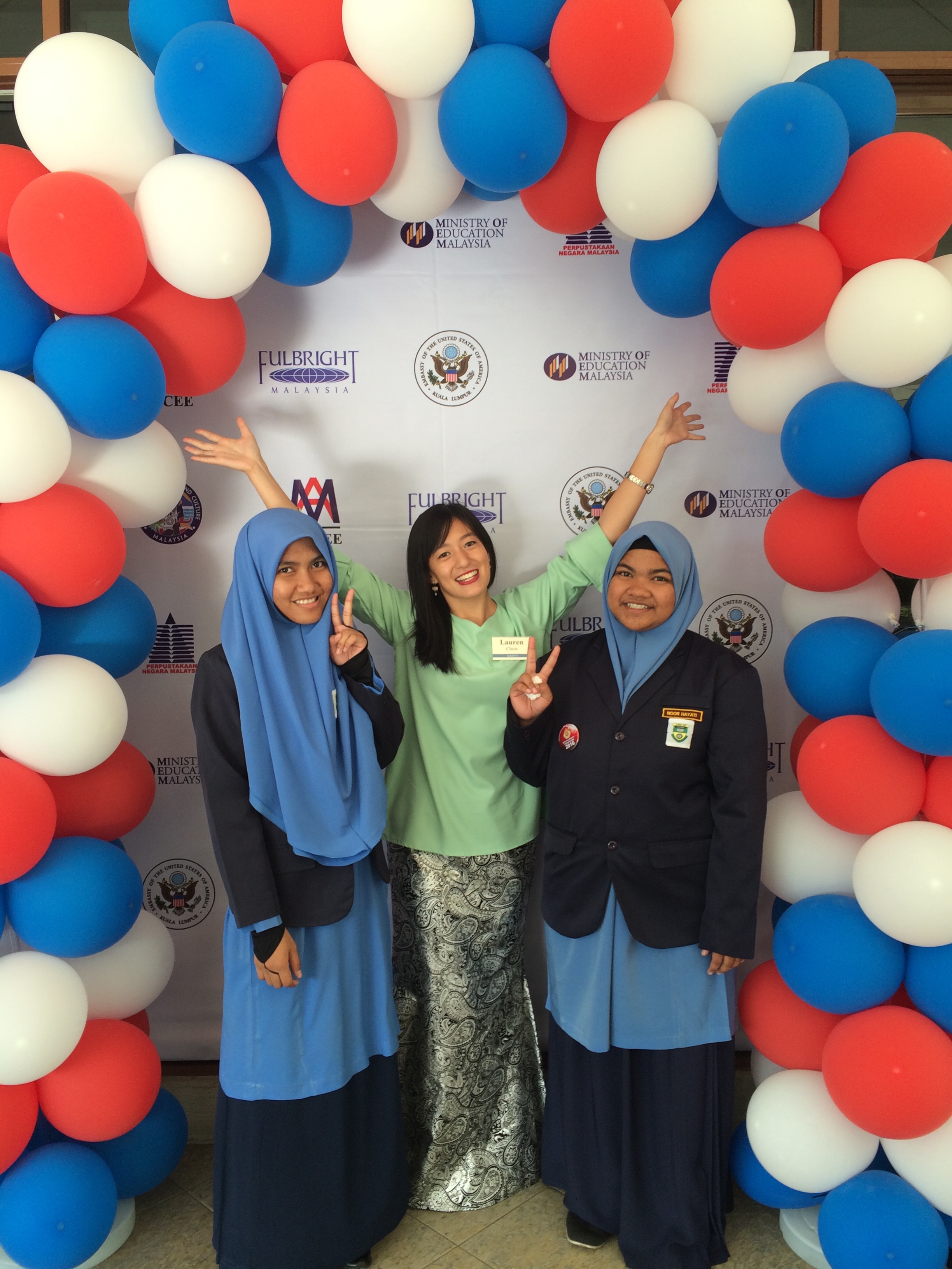 Lauren Chow with two female students in a halo of balloons