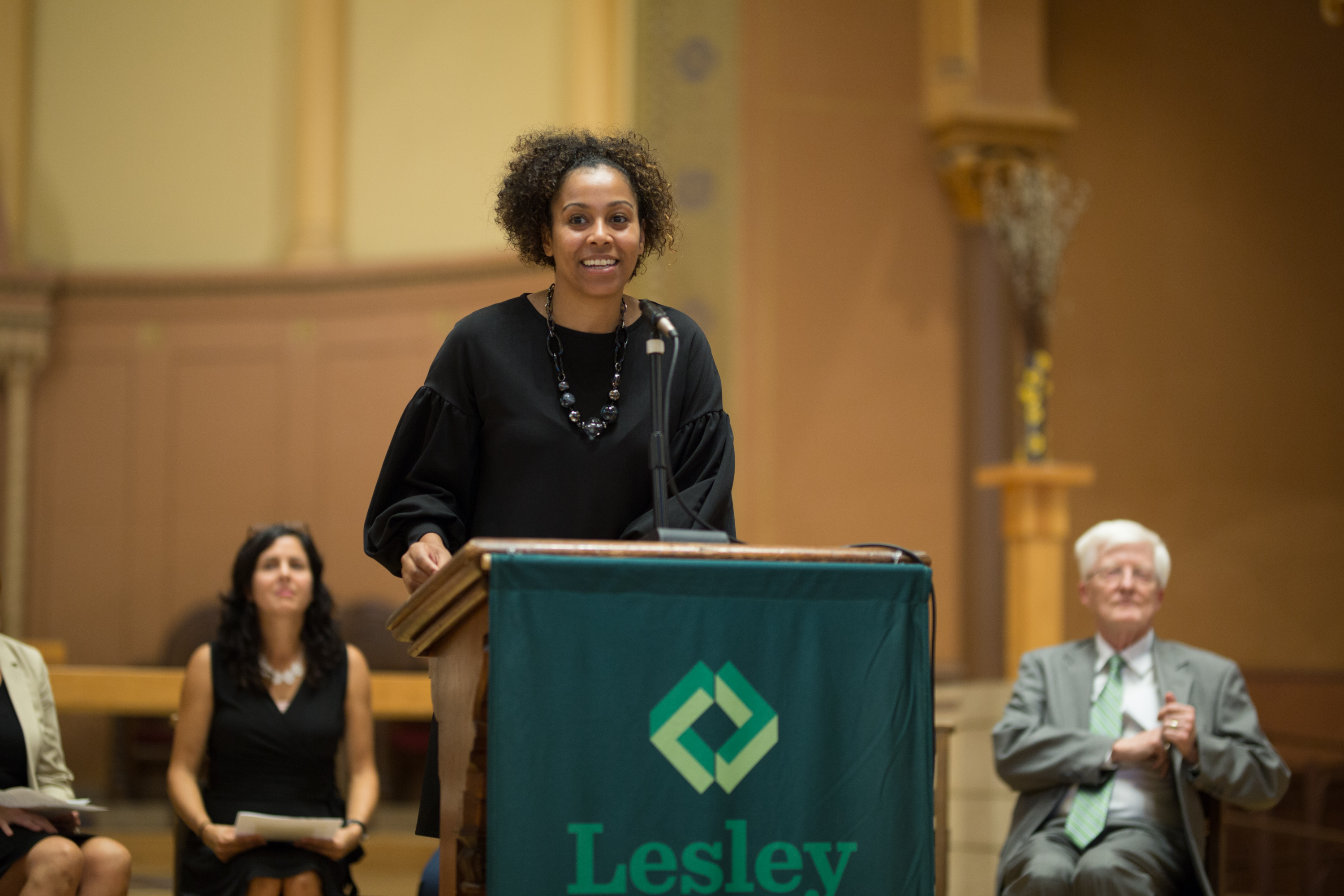 Maritsa Barros speaks at a podium in the church.