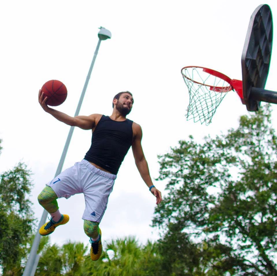 Shot from the ground up, Mike Kaufman jumps on a court with a ball in his hand.