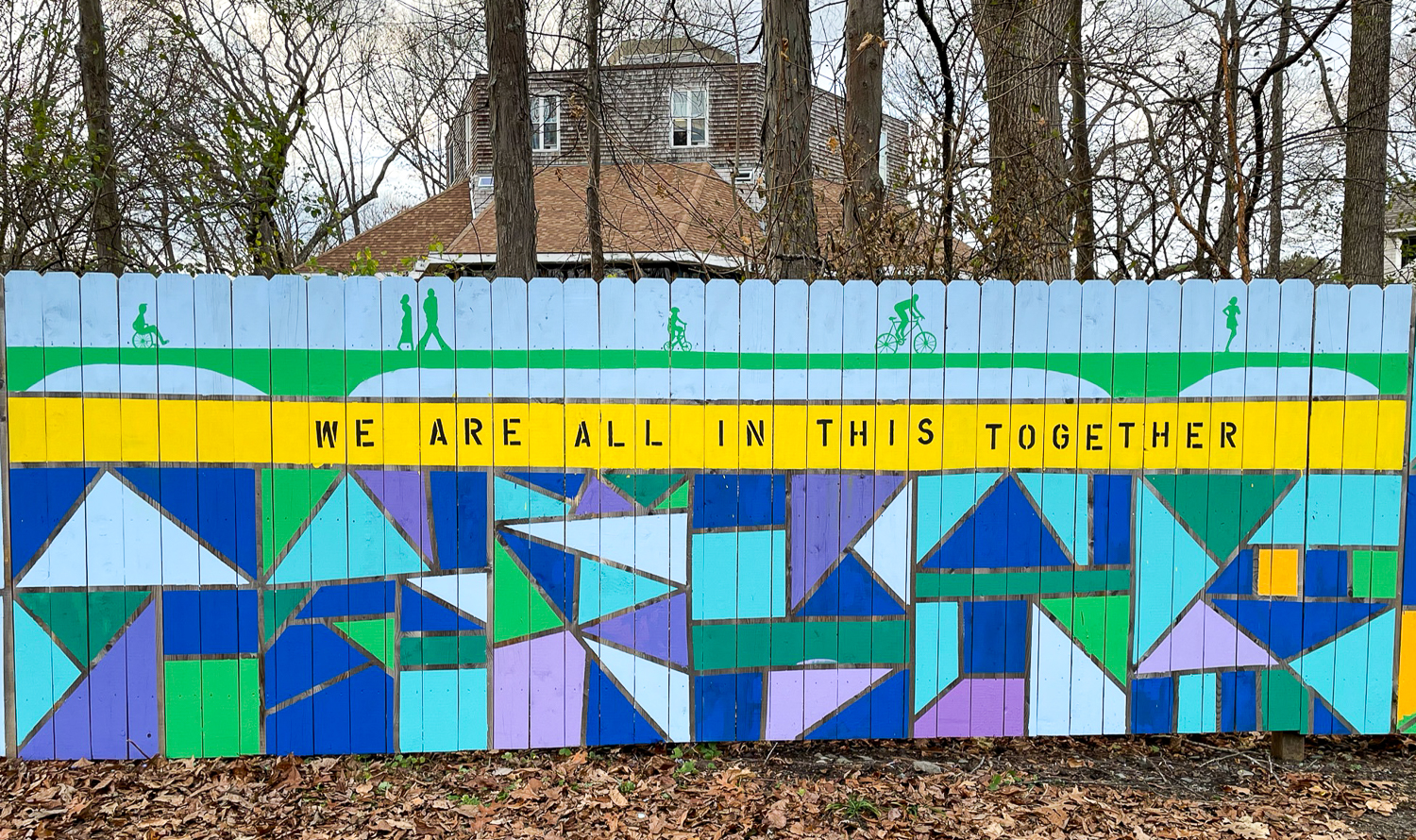 Panel of mural on a fence that reads "We are all in this together."