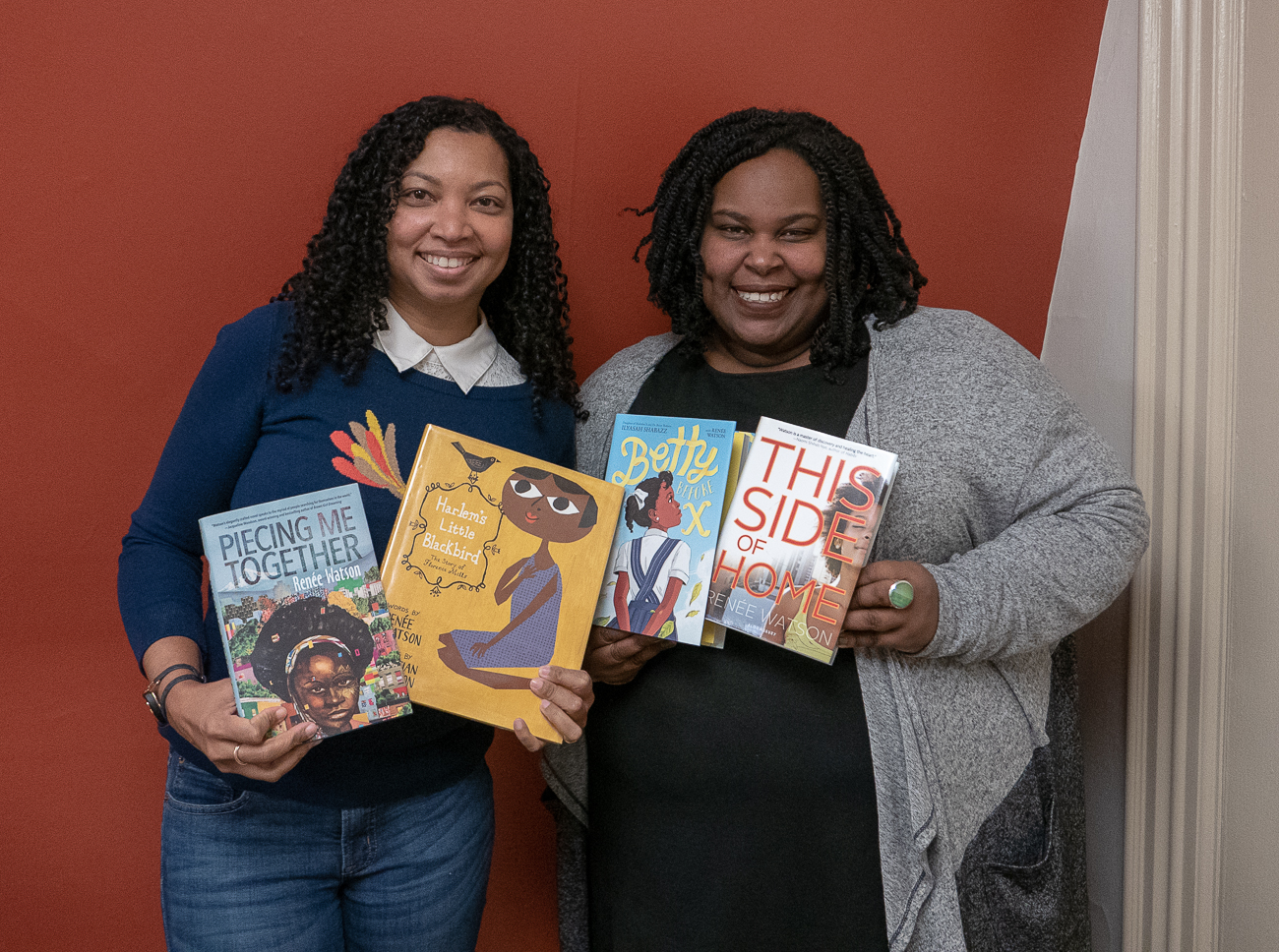 Tracey Baptiste and Renee Watson holding copies of Watson's books.