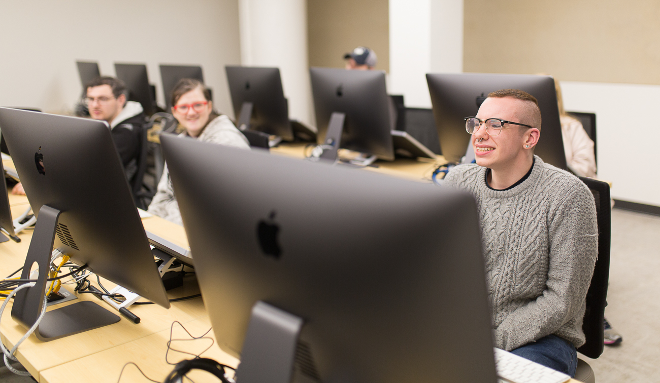 Students sit in the Apple computer room.