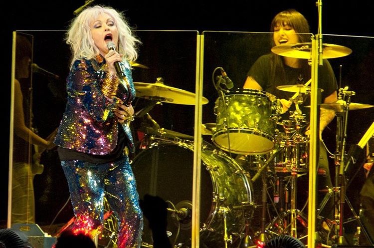 Caitlin Kalafus and Cyndi Lauper on stage at a concert.