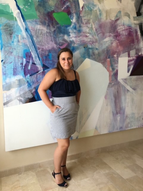 student hana fisher standing in front of a large purple and blue painting