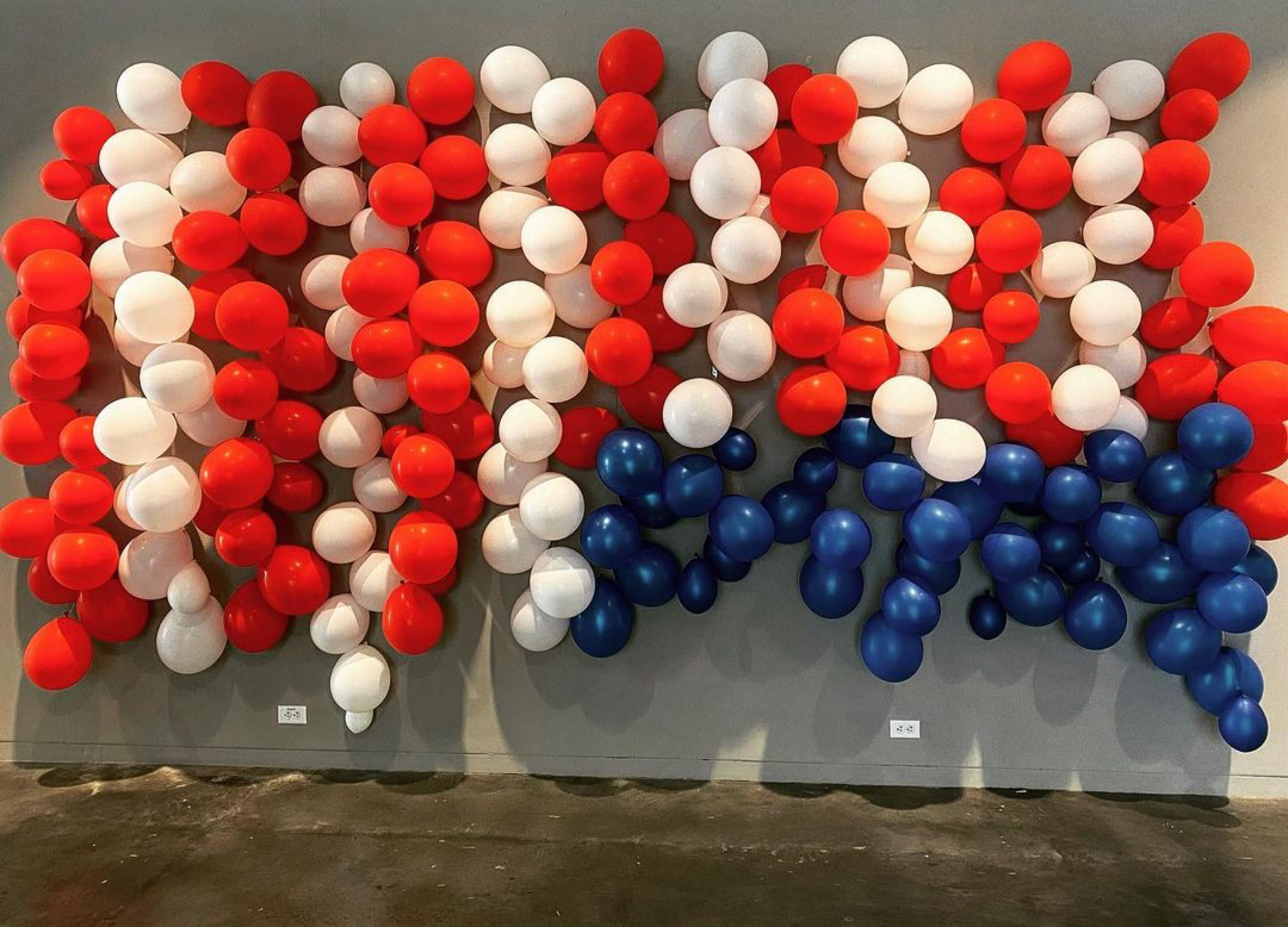 Upside down American flag made out of balloons in an art gallery