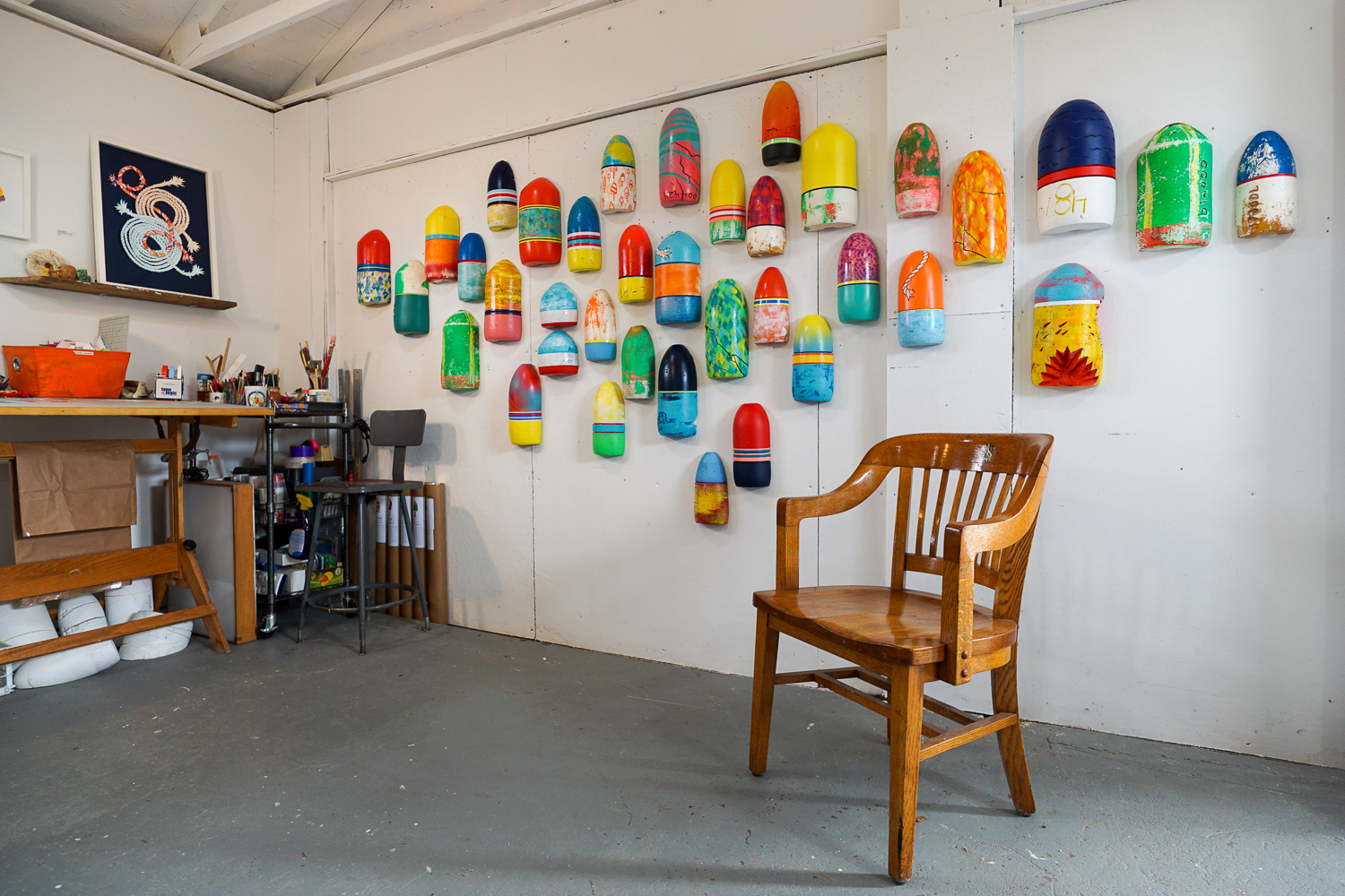 Wall with colorful buoys and a workspace in a gallery