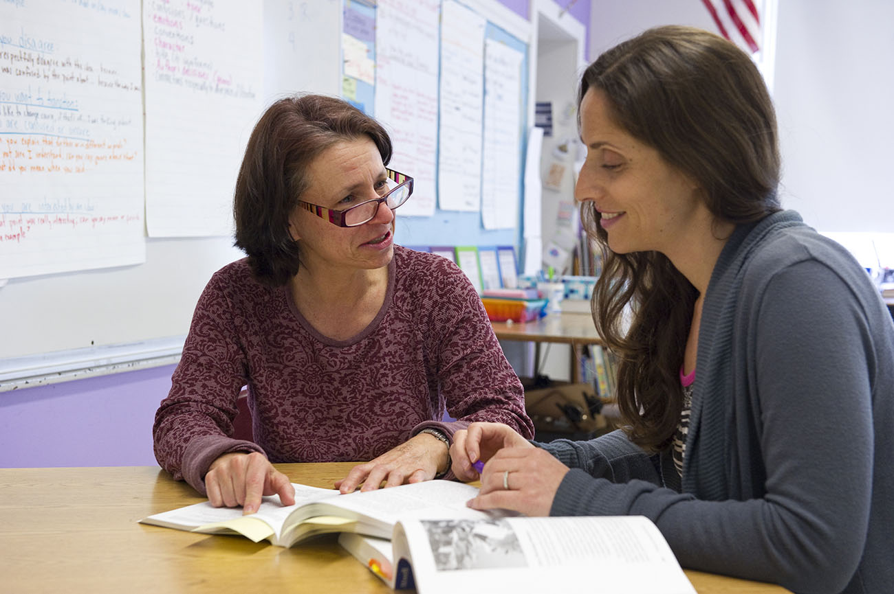 2 educators engaged in literacy coaching session