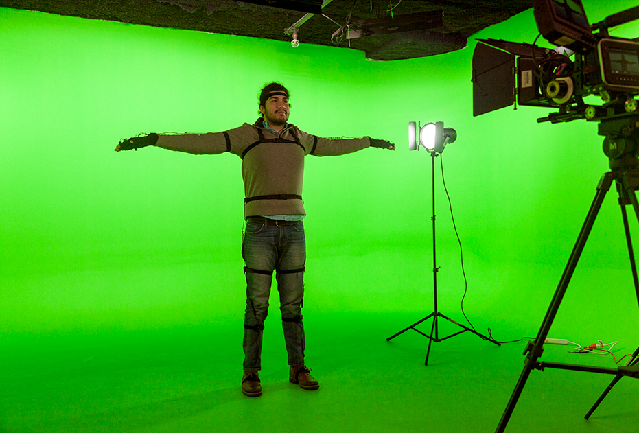 A man in Motion Capture suit in front of a green screen
