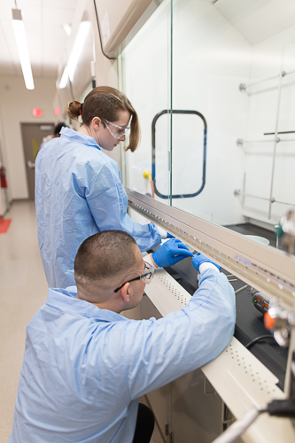 Two students work under a new fume hood in the lab.