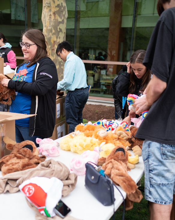 Students on the quad putting together DIY stuffed animals on a long table as a part of Quadfest.