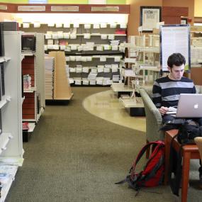student using laptop in bookstore 