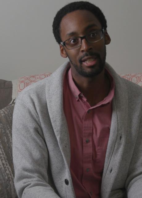 Picture of Lesley Student and Alumni Brandon Jones talking sitting on a grey arm chair