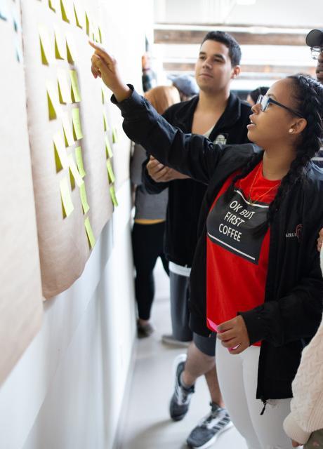 group of students looking at sticky notes on the wall