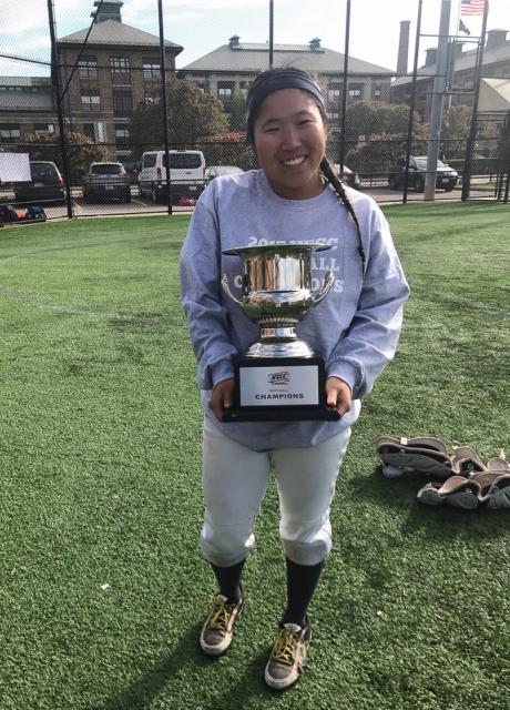 Theresa Pereira holds a trophy on a softball field