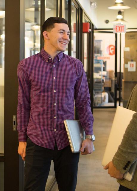 A student at his internship walking in a hallway