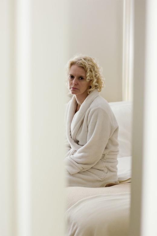 photograph of woman in white bathrobe in white room
