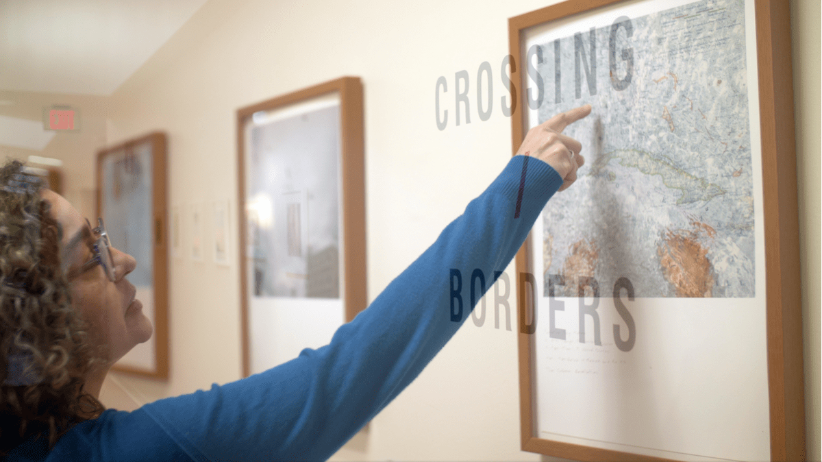 woman points to photograph on wall