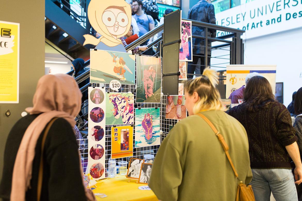 Guests browsing and looking at artwork and comic books at convention at Lesley