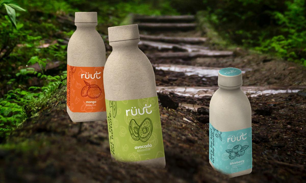 three cardboard juice bottles sit in the dirt outside