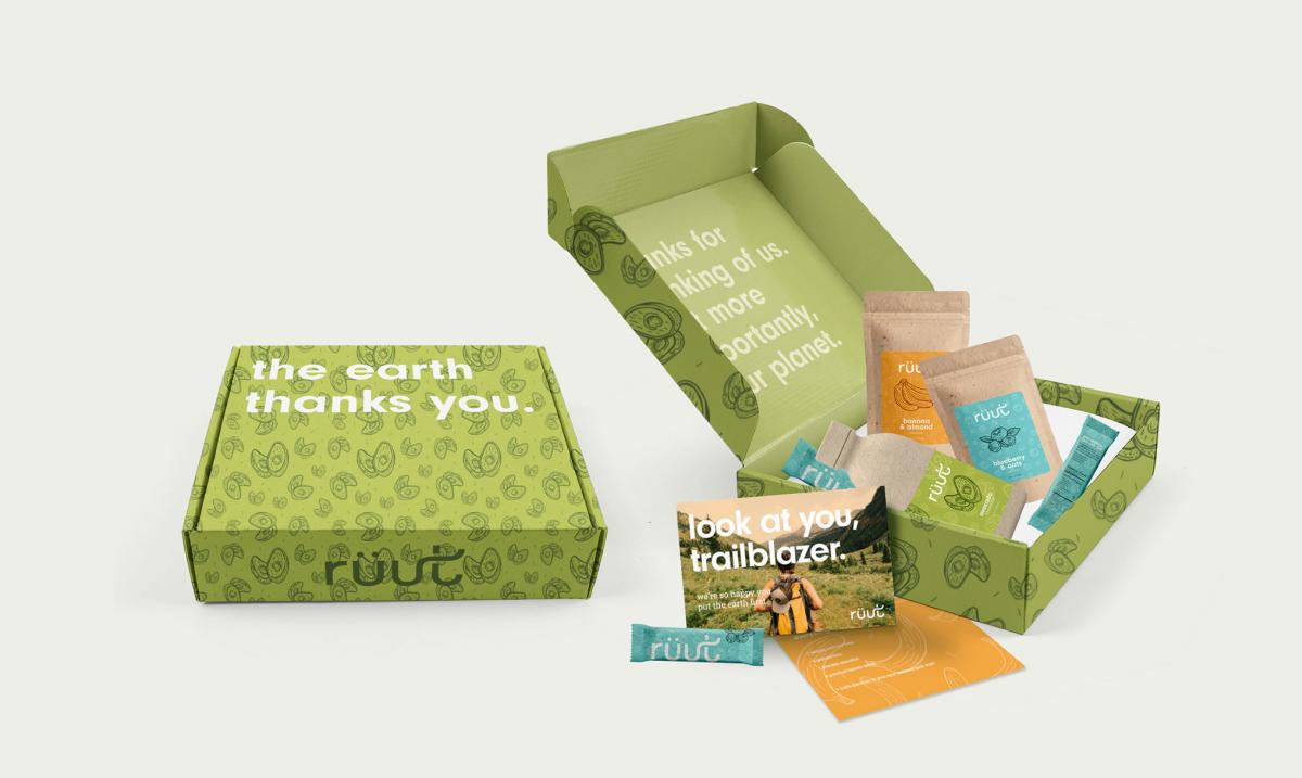 green cardboard box with granola bars and other items