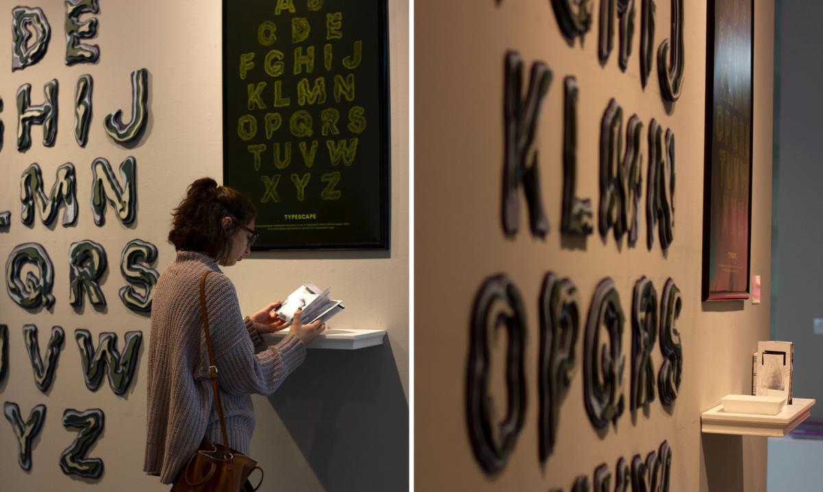 woman looks at art installation with wooden block letters on the wall