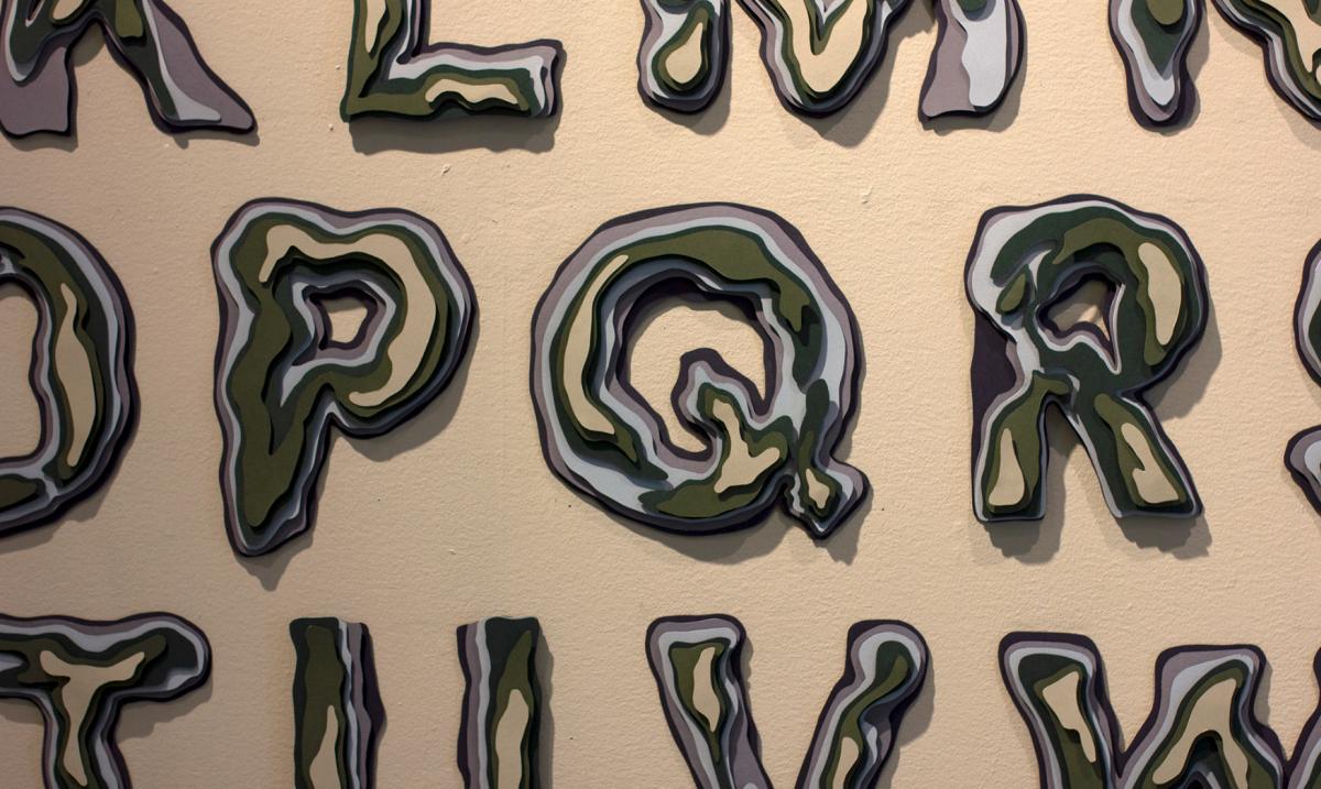 layred wooden letterforms mounted on a brown wall