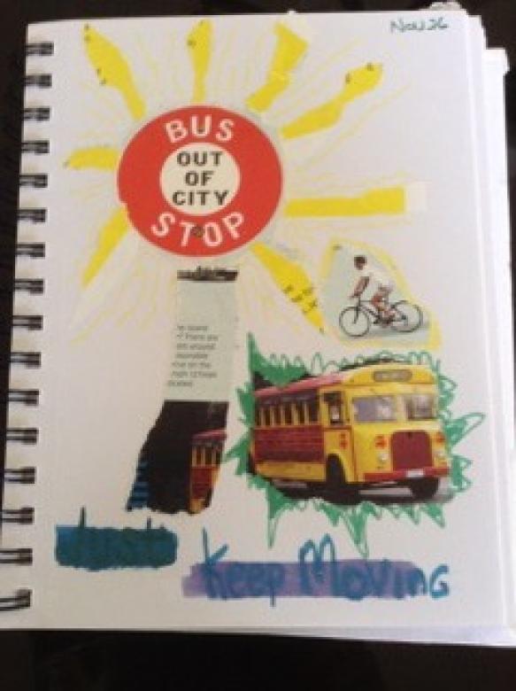 A white page of a notebook that has a Bus Stop sign surrounded by yellow lines drawn in marker, as if the sign were the sun. It also says "Just Keep Moving" in marker and has images of a school bus that appear to have been taken from a magazine 