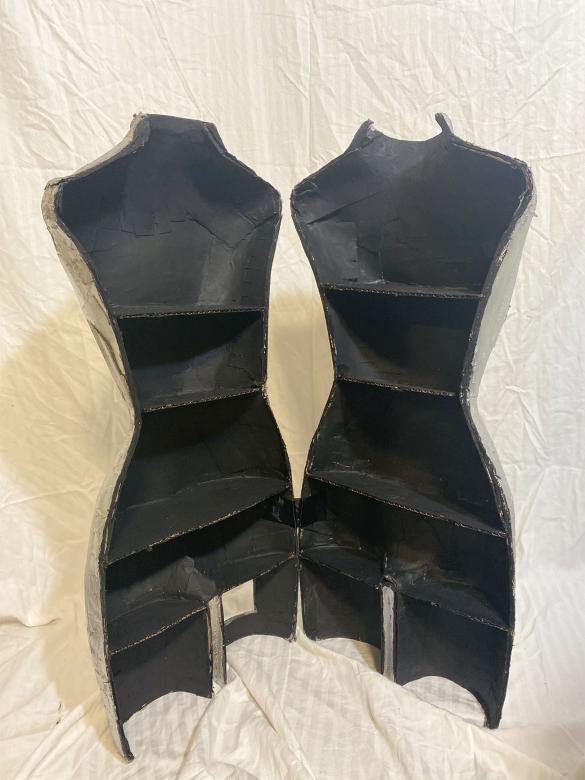 Mannequin cut in half and opened up; empty inside, painted black