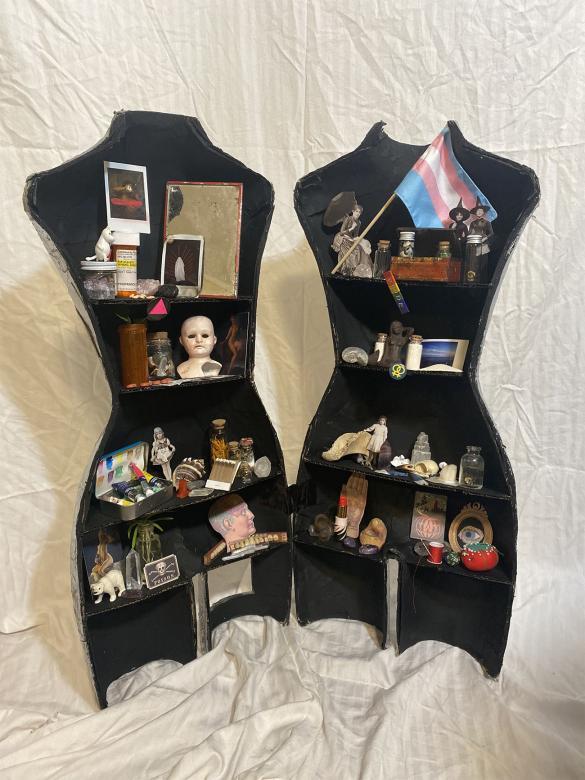 Mannequin cut in half and opened up with shelving inside that contains various trinkets