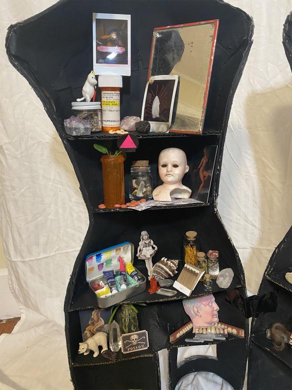 close-up of right half of mannequin, containing trinkets