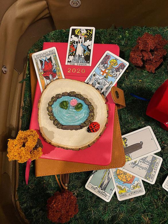 Close-up of notebooks, trinkets and tarot cards