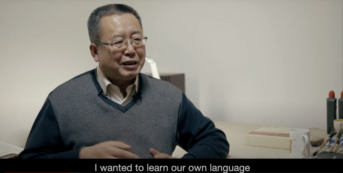 Seated middle-aged man looks off camera. The subtitle below him reads "I wanted to learn our own language."