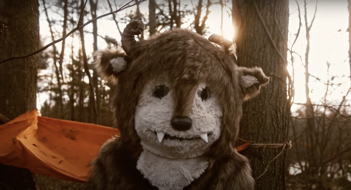Headshot of a furry beast-costumed person in the woods. 