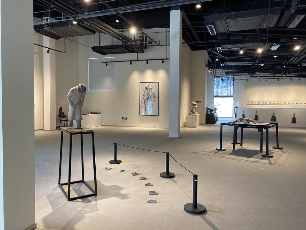 A photo from the exhibit "A Crop of Fruits." There are small sculptures on tables and artwork on the wall.