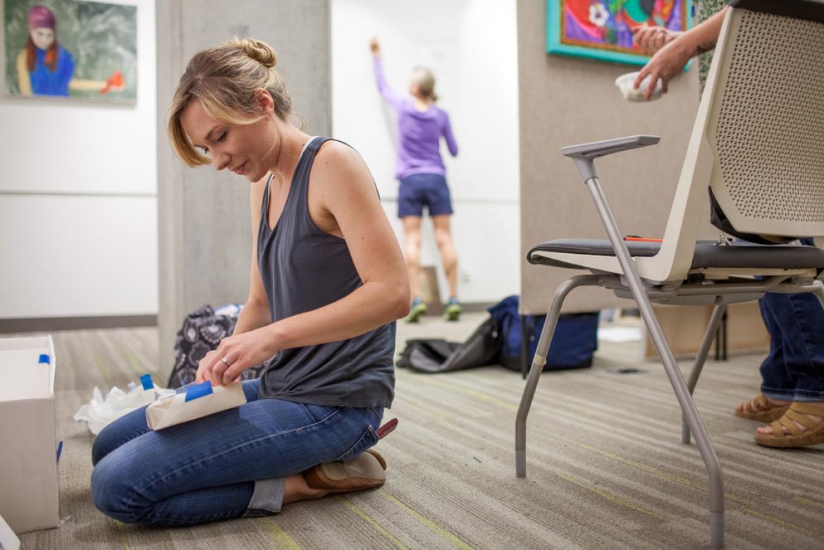 Student Elyse Kotakis sits on the floor, working on her project.